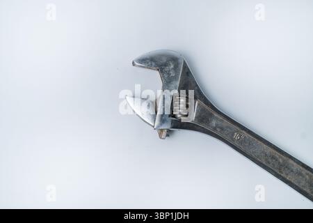 Gros plan d'une clé réglable utilisée sur fond blanc. Parfait pour les thèmes de l'outil, de la mécanique, de la réparation, de la construction ou du design industriel. Banque D'Images