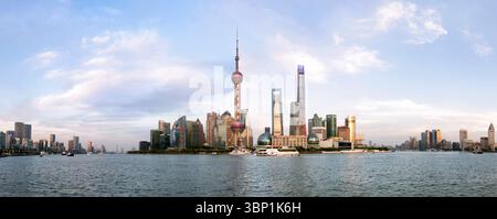 Shanghai, 20 avril 2025 : horizon de Shanghai avec architecture moderne au coucher du soleil, péniches rouillées par remblai de la ville, Chine Banque D'Images