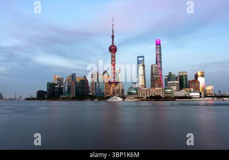 Shanghai, 20 avril 2025 : horizon de Shanghai avec architecture moderne au coucher du soleil, péniches rouillées par remblai de la ville, Chine Banque D'Images
