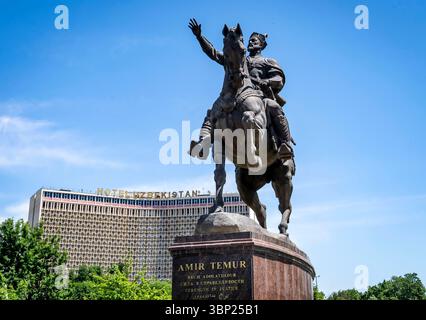 Une statue en bronze d'Amir Temur à cheval, levant une main dans un geste de leadership. La statue est posée contre un ciel bleu clair, avec une chaleur moderne Banque D'Images