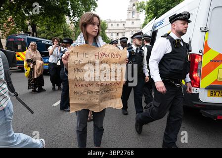 Londres, Royaume-Uni. 5 juillet 2025. Les militants de Defend Our Jurys se rassemblent près de la statue du Mahatma Gandhi sur la place du Parlement et affichent des pancartes soutenant le groupe interdit Palestine action. Il y a eu 27 arrestations. L'action palestinienne a été récemment interdite par la loi de 2000 sur le terrorisme et le fait d'être membre du groupe ou d'exprimer son soutien à celui-ci est une infraction passible d'une peine pouvant aller jusqu'à 14 ans de prison. Crédit : Ron Fassbender/Alamy Live News Banque D'Images