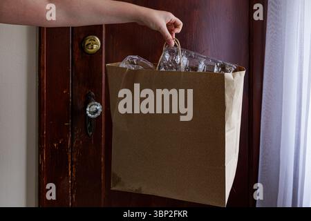 Sac en papier de recyclage ECO en main contre fond de porte en bois ancien Banque D'Images