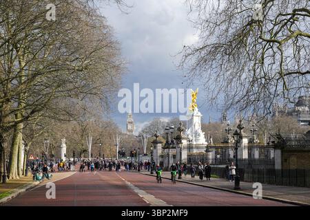 Touristes sur Constitution Hill dans Green Park, à côté du Queen Victoria Memorial et du Buckingham Palace à Londres Angleterre Royaume-Uni Banque D'Images