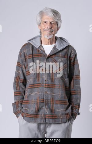 Homme plus âgé avec un sweat à capuche et les mains dans les poches de son pantalon Banque D'Images