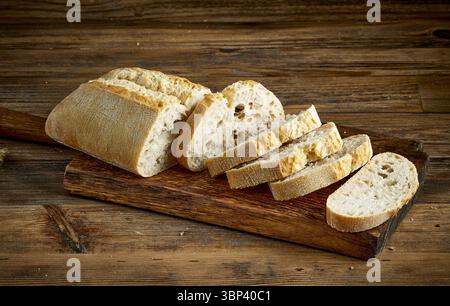 pain tranché fraîchement cuit sur la table de cuisine rustique en bois dans la boulangerie Banque D'Images