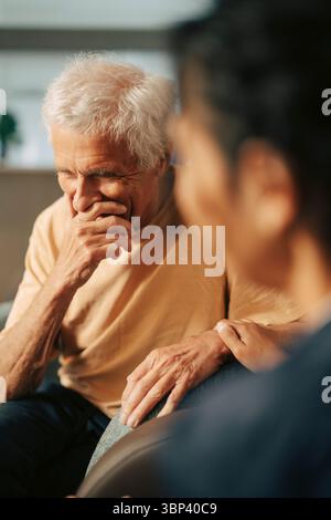 Soignante adulte consolant une patiente âgée en maison de retraite Banque D'Images