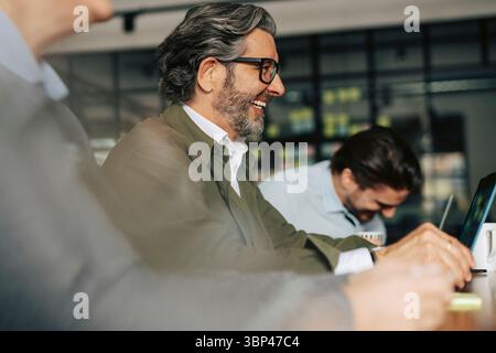 Heureux homme d'affaires senior avec des collègues en réunion au bureau Banque D'Images