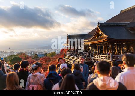 Foule de touristes photographiant la mer de feuilles d'érable rouge d'automne depuis l'emblématique temple Kiyomizu-dera au coucher du soleil. Kyoto, Japon Banque D'Images