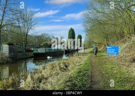 Un panneau indiquant « veuillez ralentir devant les bateaux amarrés » sur le canal Macclesfield, Kidsgrove, Stoke-on-Trent, Staffordshire, Angleterre, ROYAUME-UNI Banque D'Images