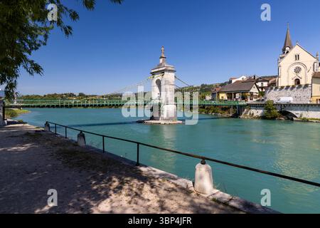 Vue pittoresque sur le Vieux Pont, un pont suspendu enjambant le Rhône entre les départements de l'Ain et de la haute Savoie, avec l'église dans le dos Banque D'Images