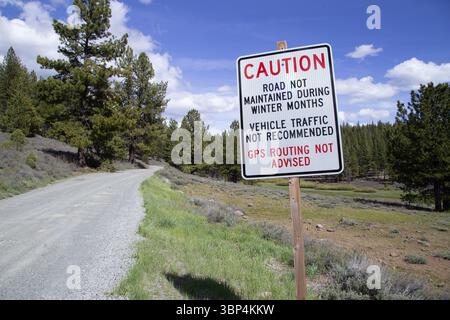 Un panneau sur une route accidentée près de Kyburz Flat dans le comté de Sierry en Californie avertit les voyageurs d'éviter les itinéraires GPS en raison d'un entretien limité Banque D'Images