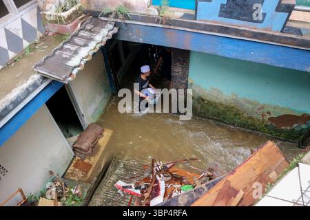 (250706) -- BOGOR, 6 juillet 2025 (Xinhua) -- Un homme patère dans l'eau de crue après de fortes pluies dans la régence de Bogor, Java occidental, Indonésie, le 6 juillet 2025. Trois personnes ont été tuées, une est portée disparue et huit autres ont été blessées après des glissements de terrain qui ont frappé la province indonésienne de Java occidental samedi après-midi, selon Hadi Rahmat Hardjasasmita, porte-parole de l'Agence provinciale de gestion et d'atténuation des catastrophes dimanche. Déclenchés par de fortes pluies, les glissements de terrain ont frappé plusieurs zones de la régence de Bogor vers 18 h, heure locale, samedi, endommageant environ huit maisons. (Photo de R Banque D'Images