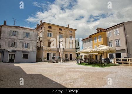 Porec, Croatie - 21 mai 2025 : bâtiments colorés traditionnels entourant la place historique de la ville dans la vieille ville avec une architecture méditerranéenne, en plein air CA Banque D'Images