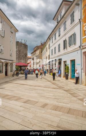 Porec, Croatie - 21 mai 2025 : belle place piétonne dans la vieille ville avec l'architecture traditionnelle en pierre d'Istrie, bâtiments méditerranéens colorés, Banque D'Images
