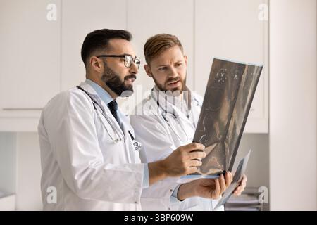 Deux médecins en neurologie regardant les rayons X contre la lumière Banque D'Images