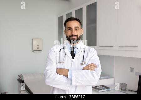 Bel homme praticien hispanique positif posant pour le portrait Banque D'Images