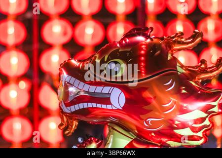 Ballon dragon rouge artisanal festif de nuit avec fond de lanterne chinoise floue. Ambiance festive orientale et charme traditionnel éclatant. Banque D'Images