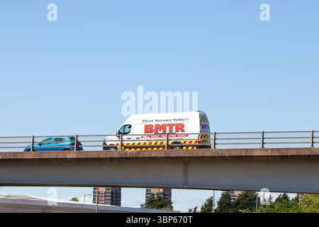Une camionnette de service mobile de montage de pneus BMTR et une voiture bleue parcourent un pont en béton préfabriqué sur la rocade A5 à Tamworth, au Royaume-Uni. Banque D'Images