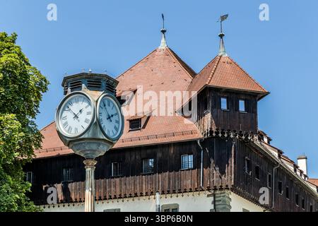 Le bâtiment du conseil à Constance avec un toit en tuiles, des murs en bois et deux tours avec des girouettes. Une grande horloge avec des chiffres romains se trouve au premier plan. Hafenstraße, Konstanz, Bade-Württemberg, Allemagne Banque D'Images