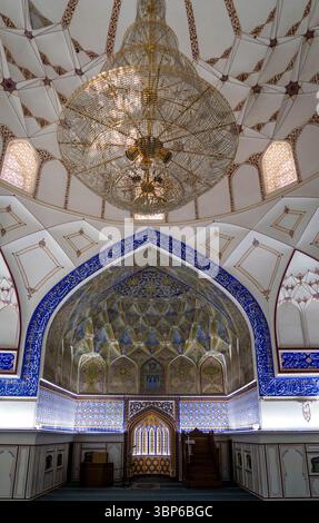 Un intérieur orné d'une mosquée avec des carreaux complexes, un grand lustre et des arches magnifiquement conçues. Le plafond présente un patt détaillé Banque D'Images