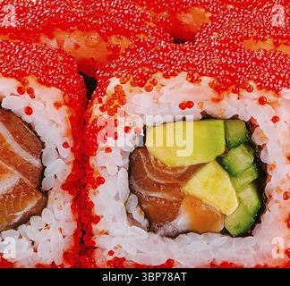 Nourriture, rouleaux de sushi californiens vibrants recouverts de tobiko rouge vif, macro Banque D'Images