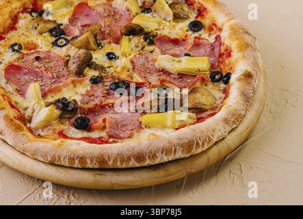 Nourriture, pizza suprême fraîchement cuite garnie de divers ingrédients sur un fond neutre Banque D'Images
