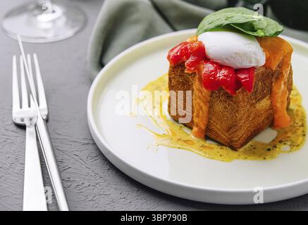 Cuisine, plat de brunch élégant avec un œuf poché sur pain grillé avec une sauce au poivron rouge Banque D'Images
