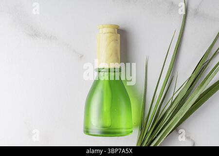 Maquette de flacon en verre compte-gouttes.Soin Fece et spa.Produits de beauté naturels.Sérum de beauté, flacon en verre dépoli vert vierge pour soins de la peau.Fond en marbre Banque D'Images