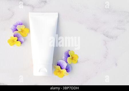 Vue de dessus de la maquette du tube en plastique blanc de bouteille souple pour la marque des cosmétiques - crème, gel, soins de la peau. Contenant à bouteille cosmétique sur table en marbre W Banque D'Images