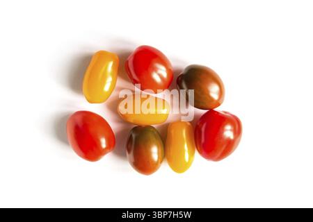 Diverses tomates colorées sur fond blanc. Vue de dessus, pose à plat Banque D'Images