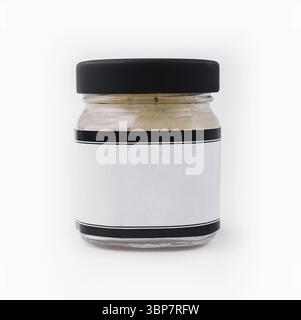 Nourriture, pot en verre transparent avec un couvercle noir et une étiquette vierge, idéal pour la marque, isolé sur fond blanc Banque D'Images