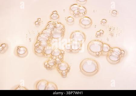 Texture de l'échantillon d'huile de sérum cosmétique transparent en gel avec fond de bulles sur rose Banque D'Images