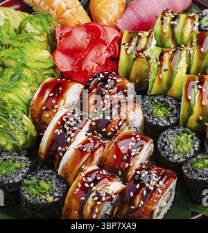 Nourriture, un assortiment de rouleaux de sushi aux couleurs vives est habilement disposé sur un plateau. Différents types de poisson frais, d'avocat et de garnitures créent un Banque D'Images