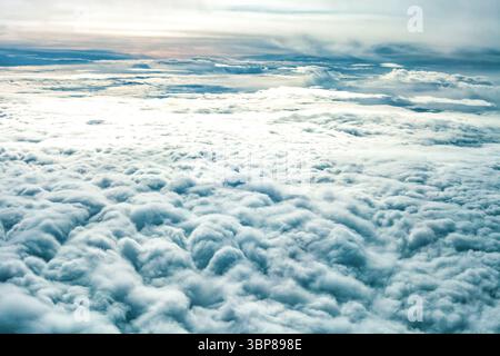 Vue aérienne expansive couches de nuages de stratocumulus blancs denses s'étendant jusqu'à l'horizon. Couverture nuageuse épaisse de la fenêtre de l'avion, mer légère de nuages. TRA Banque D'Images