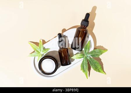 Médecine alternative, cosmétiques naturels. huile de cbd, crème pour le visage dans un pot ouvert et feuilles de cannabis cosmétiques vue de dessus, espace de copie, conception de maquette Banque D'Images