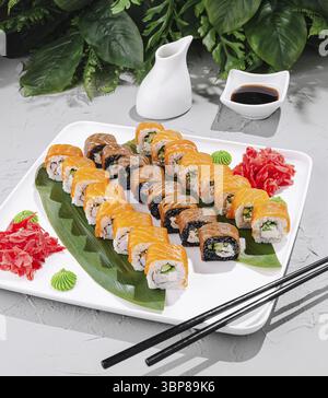 Nourriture, Un plateau de sushi magnifiquement arrangé présente différents types de rouleaux de sushi, garnis de gingembre mariné et de wasabi, accompagnés de sauce soja i Banque D'Images