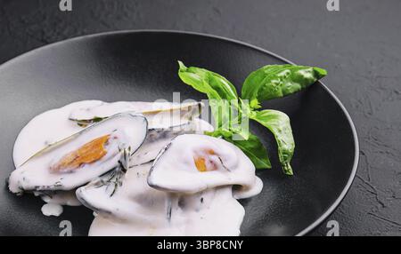Nourriture, moules dans une sauce crémeuse au fromage bleu et basilic Banque D'Images