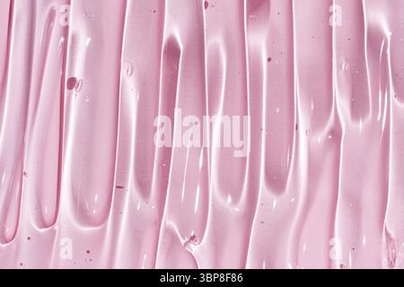 Gros plan texture gel des produits cosmétiques. crème transparente sur un fond rose avec des bulles. macro photo. flou et mise au point sélective Banque D'Images