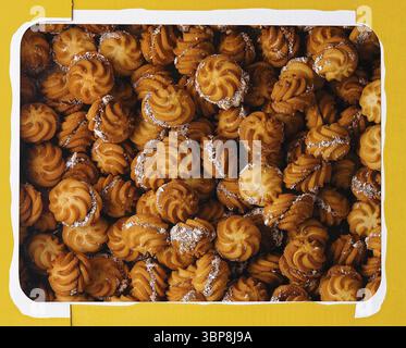 Nourriture, vue de dessus d'une boîte jaune remplie de biscuits bruns dorés gros plan Banque D'Images