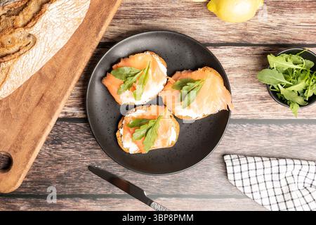 Vue de dessus de toasts de saumon fumé et salé servis avec roquette Banque D'Images