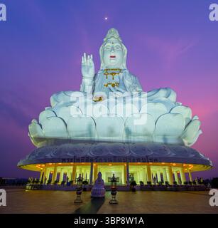 Statue blanche massive de Guan Yin, la déesse bouddhiste de la Miséricorde, assise dans une méditation calme au-dessus des jardins du temple de Wat Huai Pla Kang à Chiang Rai Banque D'Images