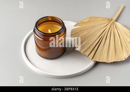 Handgemachte Kerze aus paraffin und Sojawachs in einem Glasgefaess auf einem BetonTabt. Kerzenherstellung. Minimalismus. Tablette de weisse luxurioese Banque D'Images