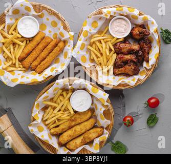 Nourriture, vue de dessus des ailes de poulet frites, des bâtonnets de mozzarella et des frites servies avec une sauce trempette Banque D'Images