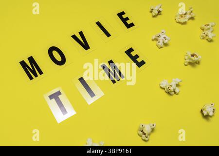 Temps du film texte lettrage avec le pop-corn salé dispersé sur fond jaune Banque D'Images