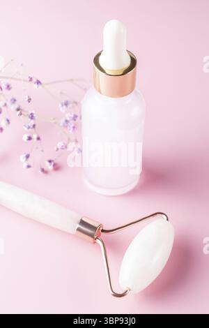Pipette cosmétique avec flacon d'acide hyaluronique ou de sérum et rouleau de jade pour le massage du visage.Soins de la peau de routine, levage et tonification, traitement d'acupression. Banque D'Images