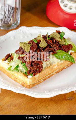 tomates séchées au soleil, pesto et iceberg sur une gaufre belge Banque D'Images