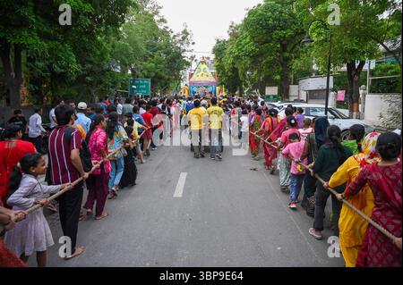 NOIDA, INDE - 6 JUILLET : des dévots tirent le char transportant Lord Jagannath, son frère Balabhadra et sa sœur Subhadra parmi les personnes rassemblées lors de la procession de Jagannath Rath Yatra, dans le secteur 34, le 6 juillet 2025 à Noida, Inde. Jagannath Rath Yatra, également connu sous le nom de Festival chariot ou Shree Gundicha Yatra, est un festival hindou majeur célébré chaque année dans la ville côtière. Le célèbre festival, généralement célébré en juin-juillet, commence lorsque Lord Jagannath et ses deux frères et sœurs - le frère aîné Lord Balabhadra et la sœur cadette Devi Subhadra sont prêts à donner le darshan au public dans le chariot Banque D'Images