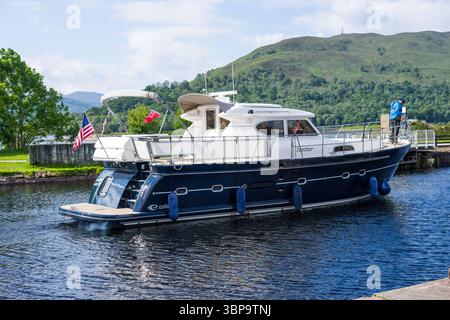 Lancement à moteur passant par l'écluse inférieure sur le canal calédonien à Corpach près de Fort William, Highland, Écosse, Royaume-Uni. Banque D'Images