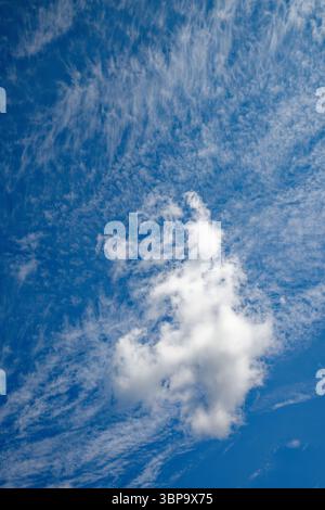 Formation de nuages blancs et tordus contre un ciel bleu ensoleillé Banque D'Images