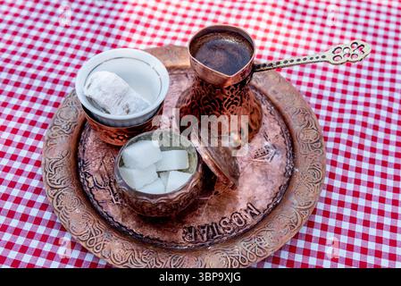 Le café turc traditionnel infusé en cezve sur le sable est servi dans une petite tasse de bonbons Banque D'Images